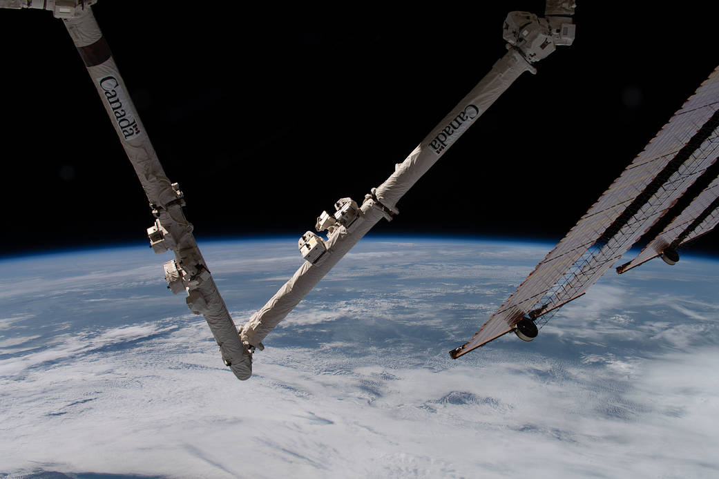 The International Space Station Canadarm2 and solar array above Earth